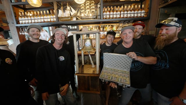 The winning crew rings the bell, briefcase of fifties open