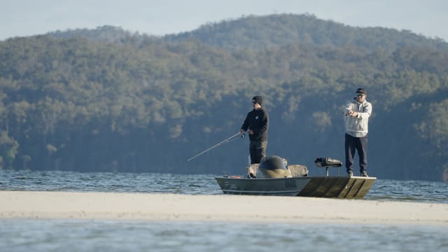 Two anglers casting off a sandbar in the morning sun