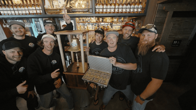 The Rowdy Floyd's crew at the bell with the case of prize money at Scallywags