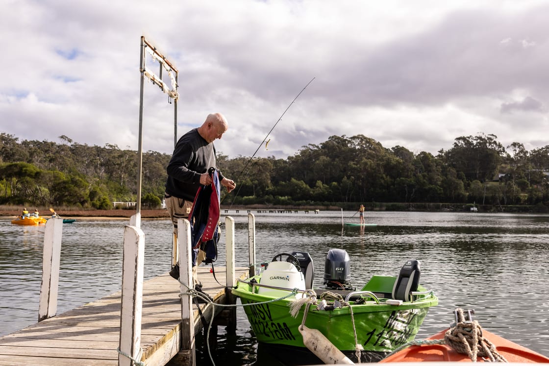 A man rigging a fishing rod on the jetty at Mallacoota