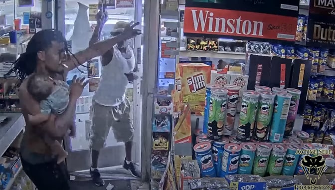 Man Holding Child Has To Fend Off Man With Gun