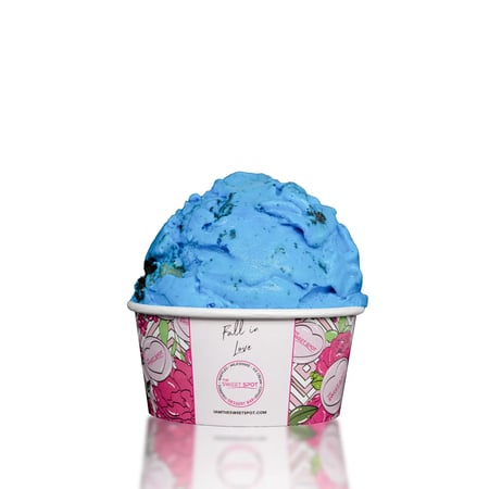 A creamy vanilla ice cream, colored blue, loaded with crushed cookie pieces and cookie dough chunks.