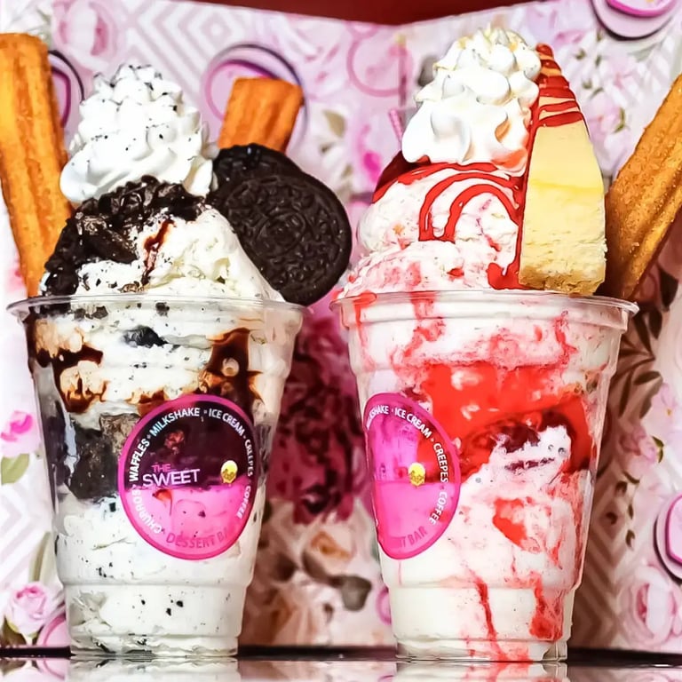 Two cups of ice cream. Oreo cookies and cream ice cream, strawberry cheesecake ice cream, whipped cream churros, and a cheesecake.