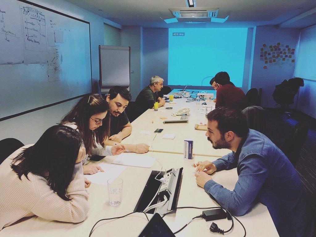 Bir masanın etrafında oturmuş bazı insanlar bir konu üzerine tartışıyorlar.