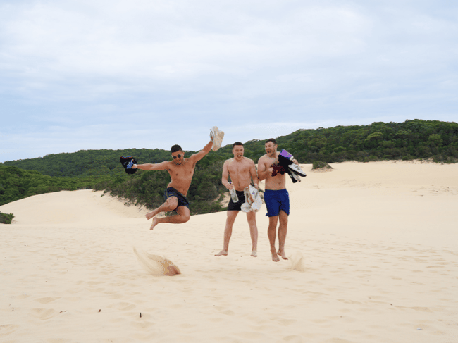 Tour group posing on sand dunes at K'gari Fraser Island