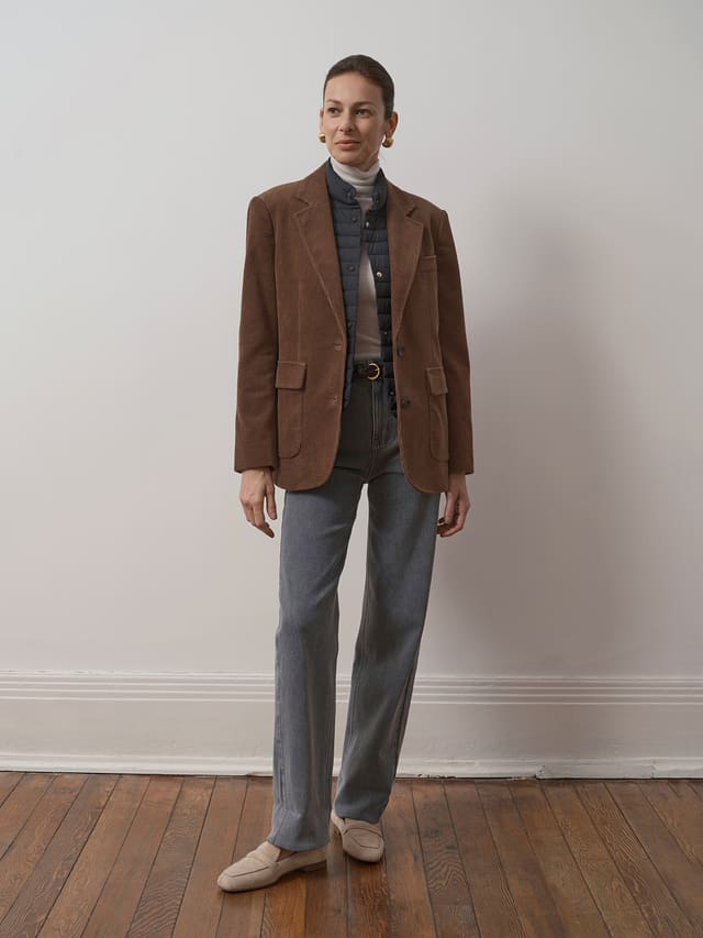 Model wearing andreatang KIMBERLEY corduroy blazer layered over quilted vest and turtleneck with grey trousers
