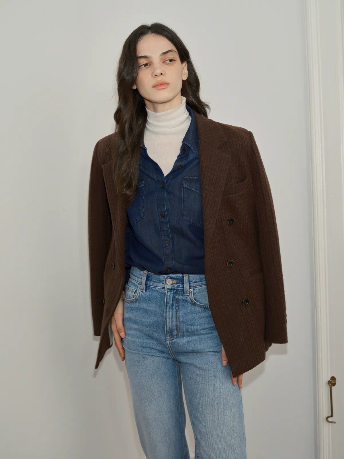 Model wearing CINDY denim shirt under brown textured blazer, ivory turtleneck, light wash jeans
