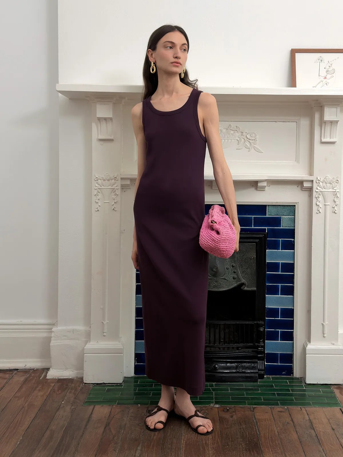 Plum AUBREY dress styled with pink crocheted clutch in front of ornate fireplace