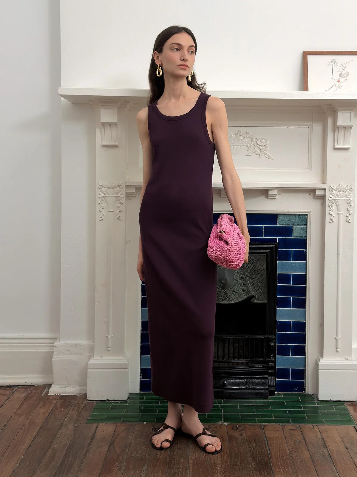 Plum AUBREY dress styled with pink crocheted clutch in front of ornate fireplace