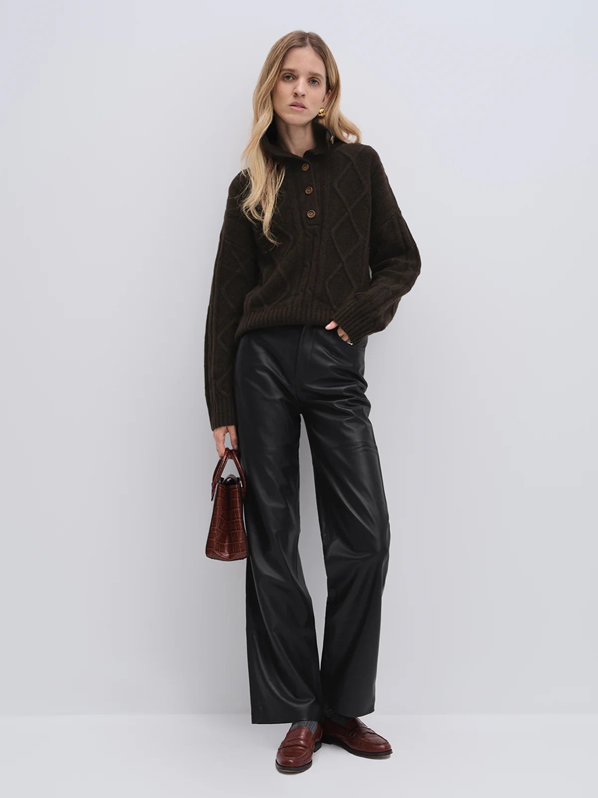 Model wearing andreatang dark brown yak and wool buttoned collar sweater with black wide-leg trousers