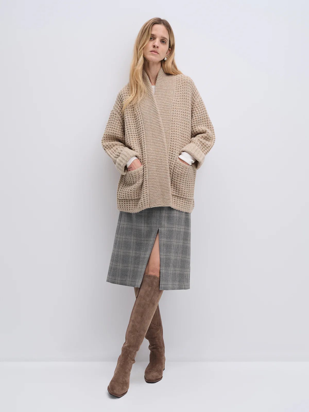 Side view of the Apricot textured knit cardigan worn over a top and skirt, no embroidery visible.