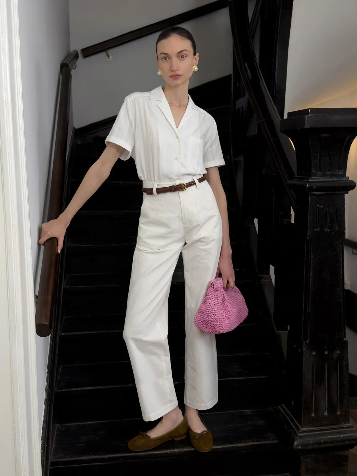 Andreatang ISADORA white cotton jacquard short sleeve shirt styled with white wide-leg trousers and brown belt on staircase