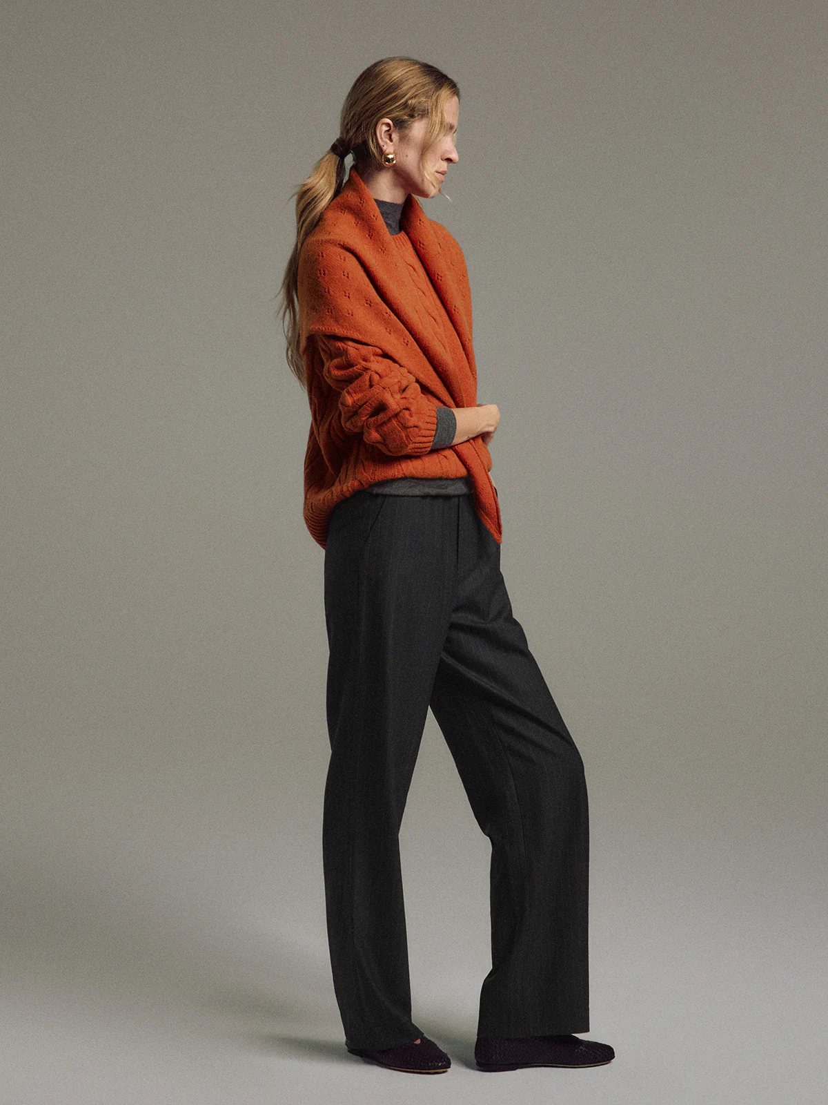 Close-up of Gray/White pinstripe wool-blend straight trousers showing elastic waistband with 'ANDREA TANG' branding and front pockets.