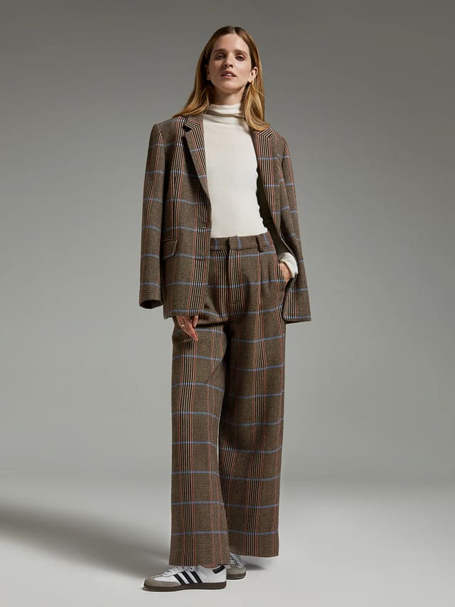 Model wearing andreatang pure-wool British check blazer with matching wide-leg trousers and ivory turtleneck