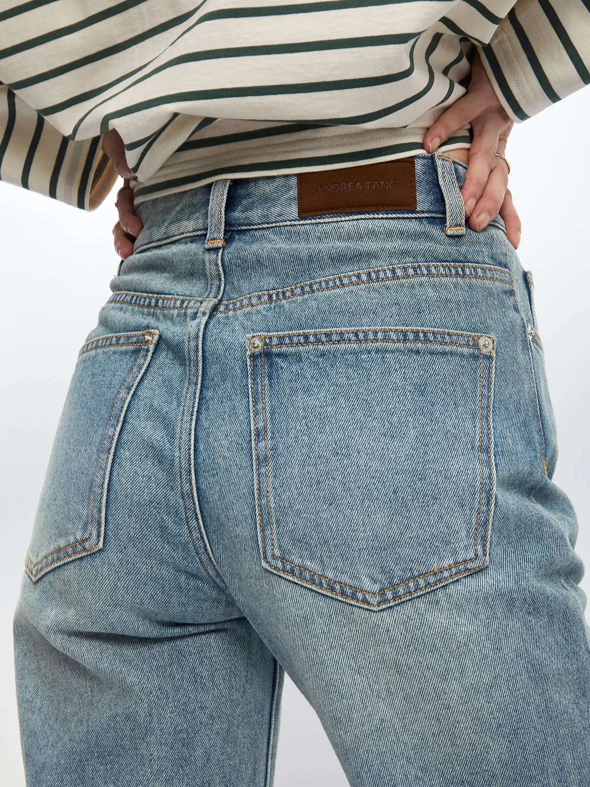 Rear close-up of blue retro washed split flared jeans showing back pockets, leather waistband patch, and stitching.