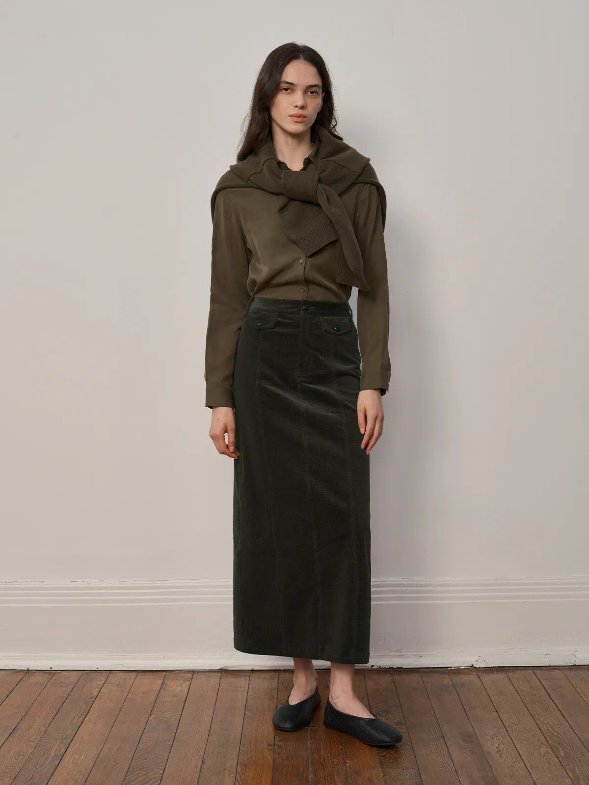 Full-length front view of CHIARA skirt styled with olive shirt, draped knit scarf, and black flats