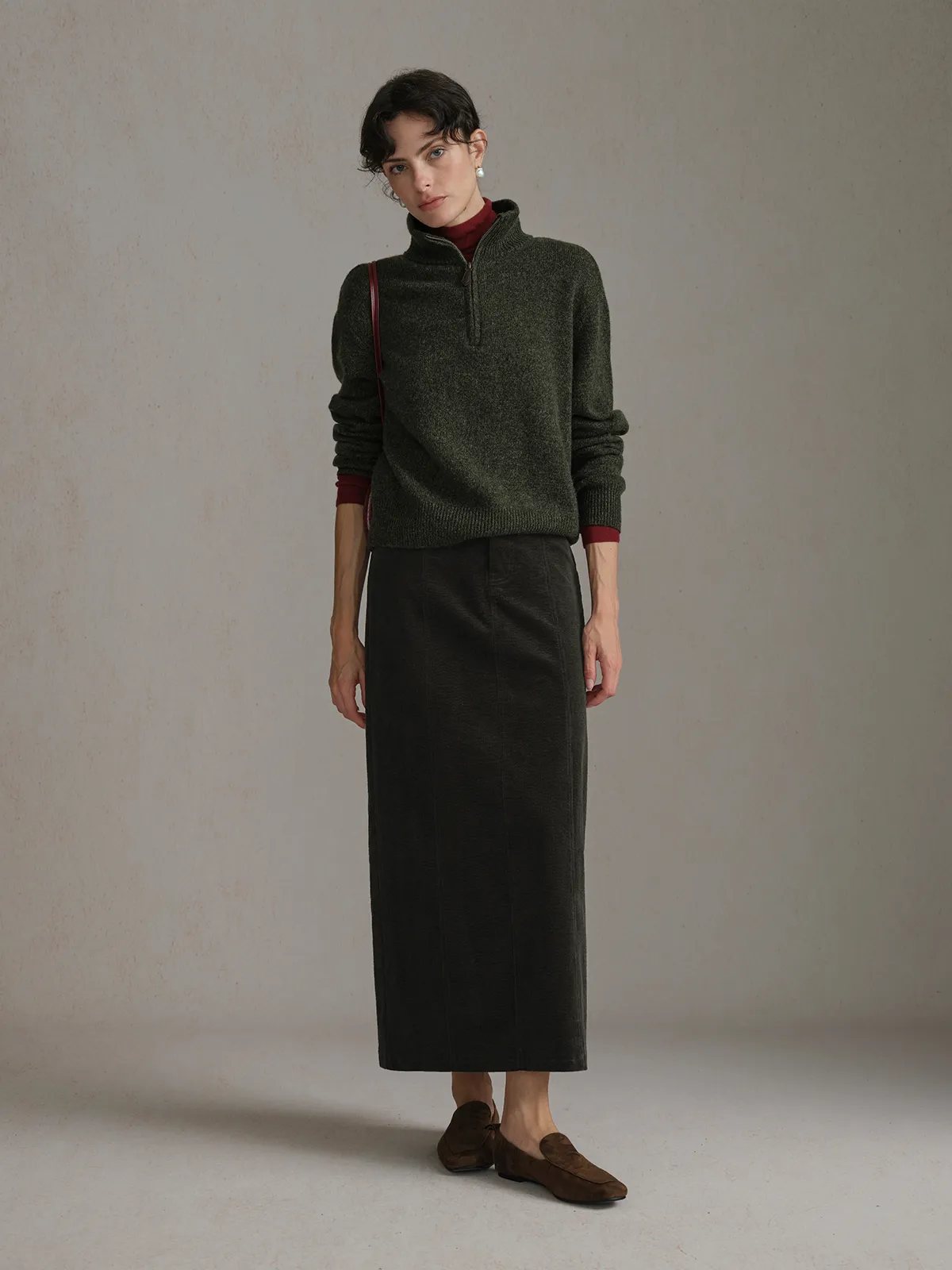 andreatang CHIARA Wavy Corduroy Midi Skirt in olive green worn with olive half-zip sweater and brown loafers, front full-body view