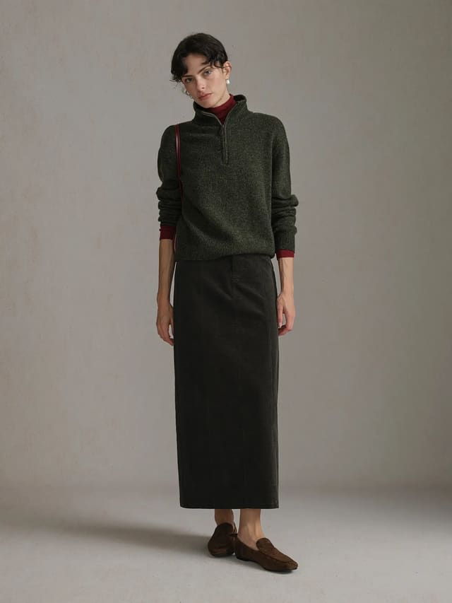 andreatang CHIARA Wavy Corduroy Midi Skirt in olive green worn with olive half-zip sweater and brown loafers, front full-body view