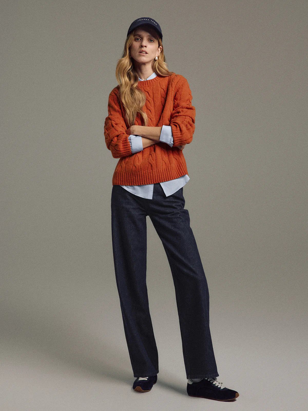 Side view of model wearing Blue raw denim straight-leg jeans with a blouse and dark loafers.
