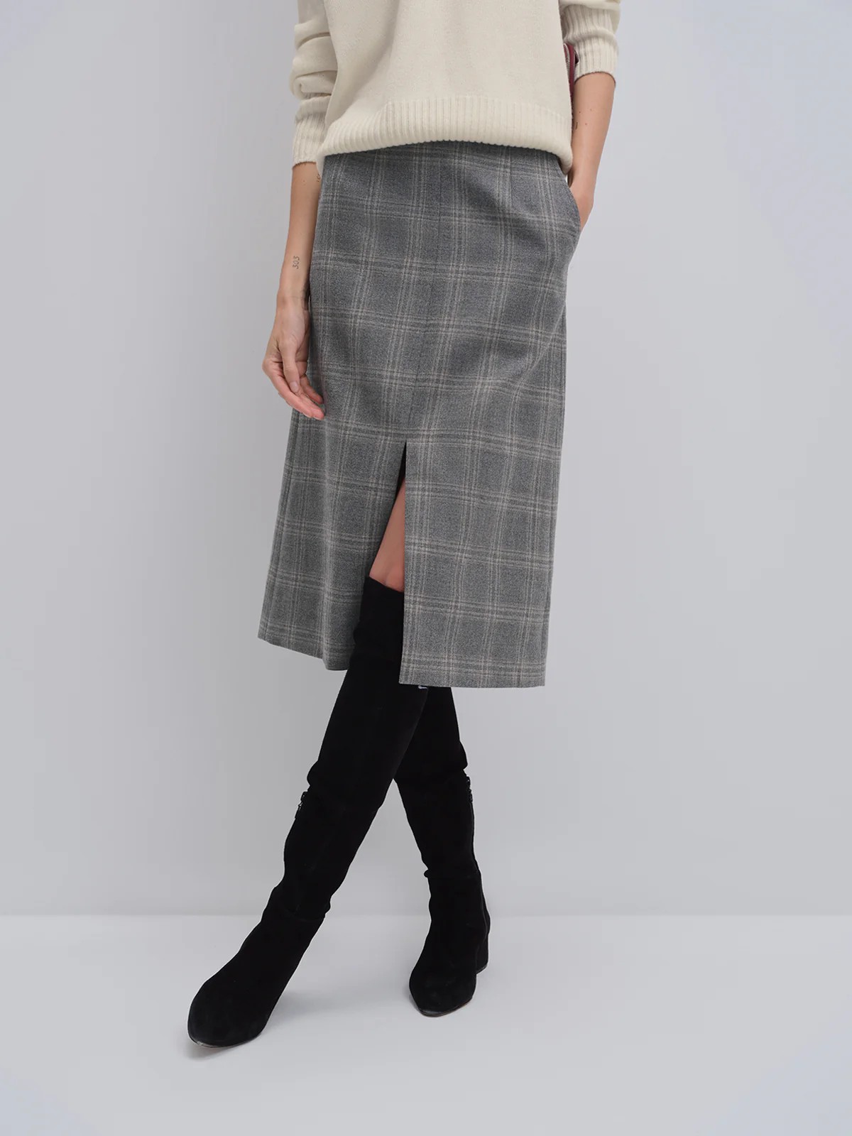 Close-up of andreatang wool check midi skirt showing blue-grey plaid and front vent detail