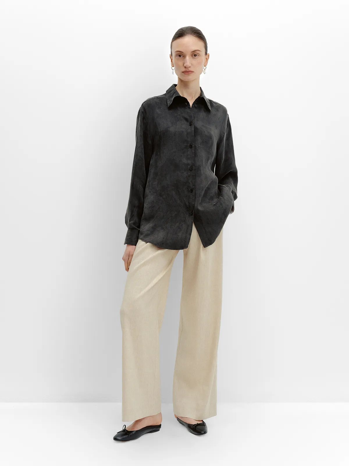 Model in black washed-silk shirt and FINN linen trousers, front pose