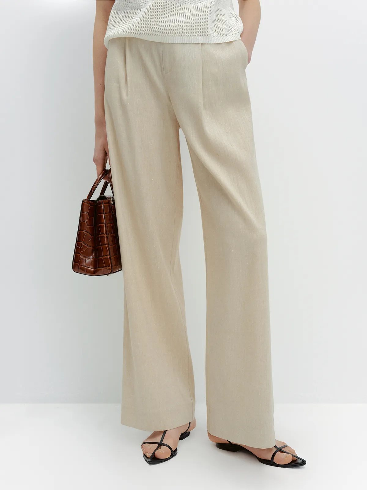 Mid-shot of FINN linen trousers with hands in pockets, showing front pleat and fabric texture