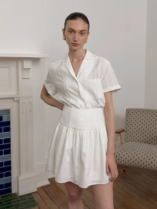 Front view of model in ISADORA white shirt paired with white gathered mini skirt and corset-style waistband