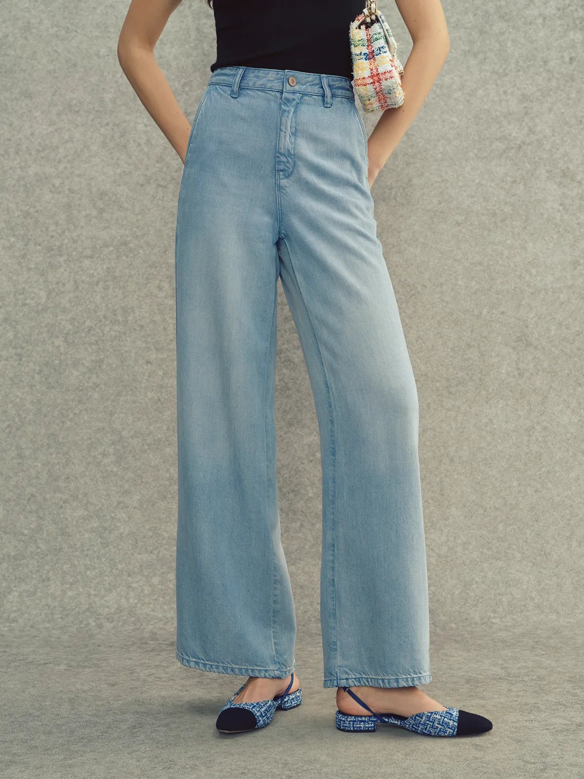 Front full-body view of LEANNE wide leg jeans with hands in pockets, highlighting relaxed fit and hem detail