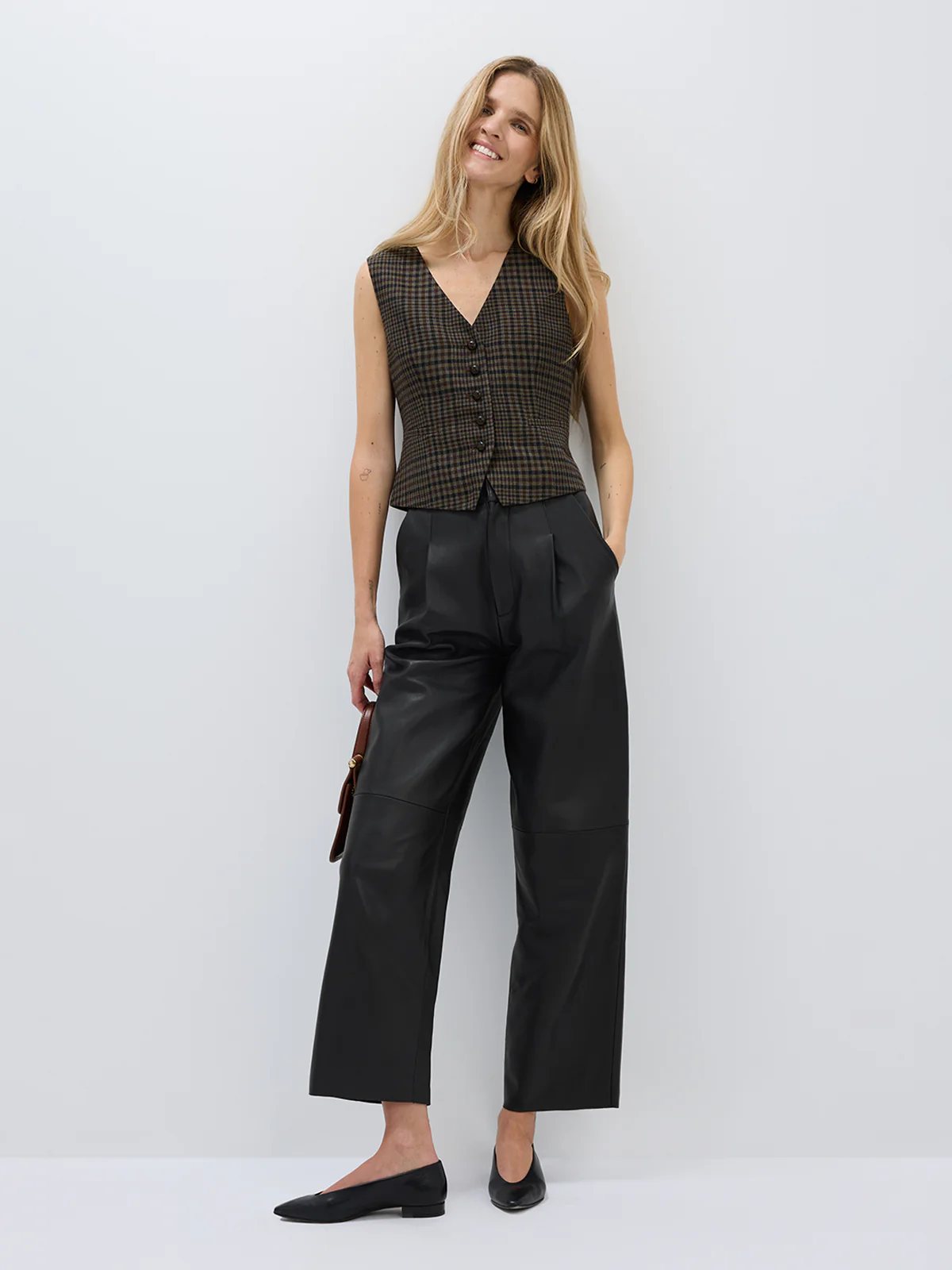 Front view of model in andreatang wool-blend check vest with black cropped wide-leg trousers and flats
