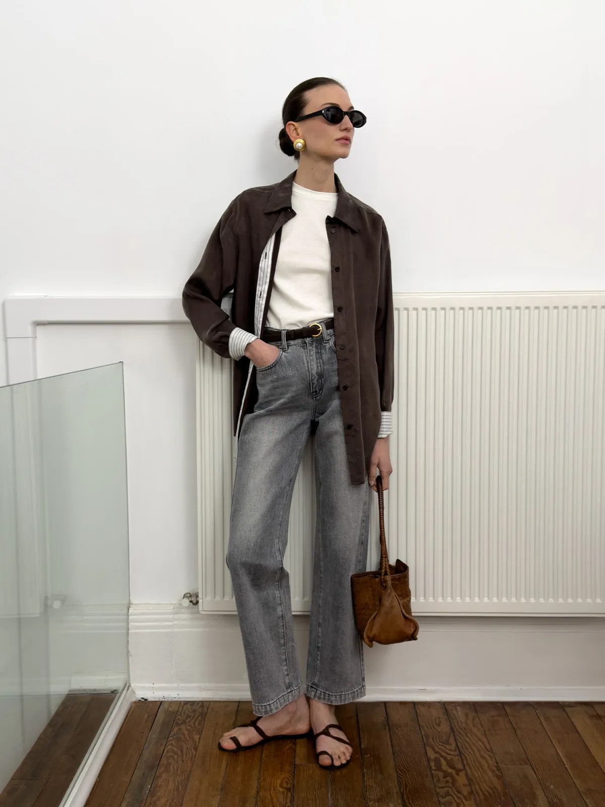 andreatang LUCA fitted t-shirt layered under brown oversized shirt with striped cuffs, paired with grey jeans and leather bucket bag