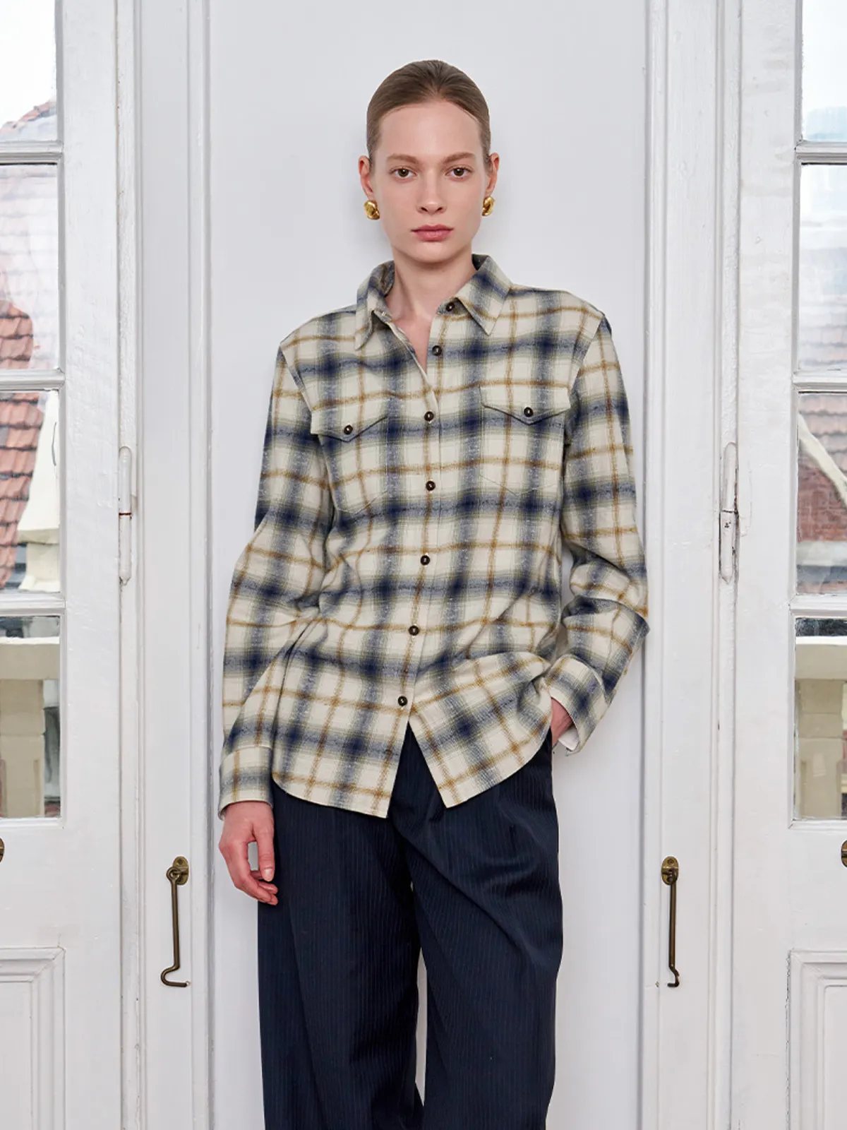 Front-facing model wearing Andreatang BRAMBLE distressed plaid shirt with hands in pockets