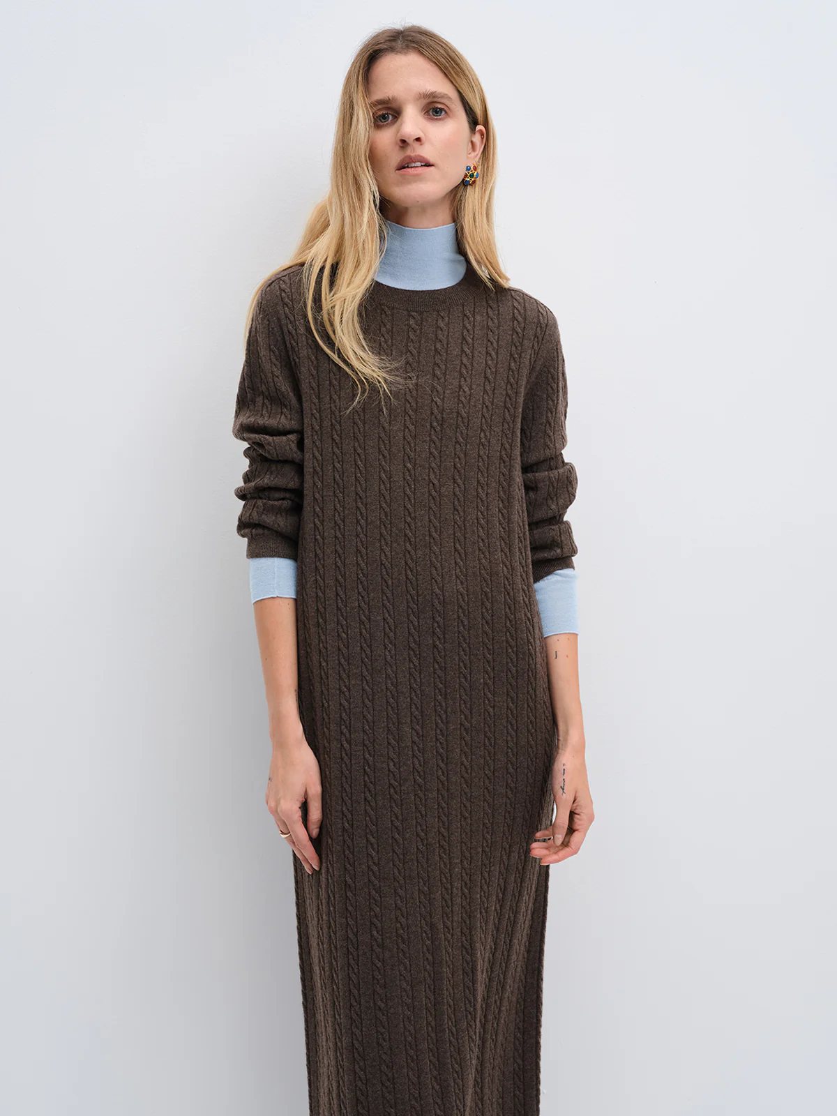 andreatang dark brown Merino cable-knit maxi dress layered over a pale blue turtleneck