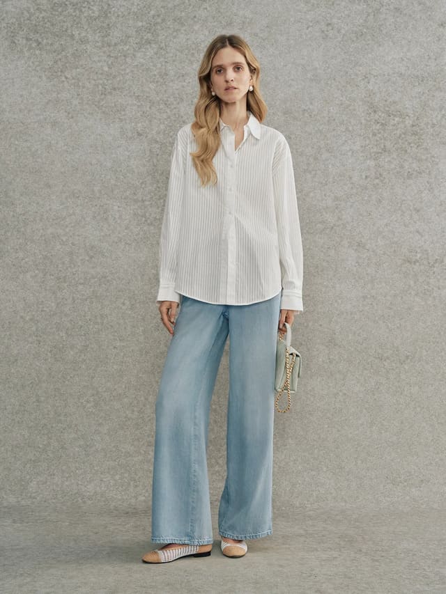 Full-body look: Andrea Tang KIARA striped shirt styled with light-wash wide-leg jeans and woven flats