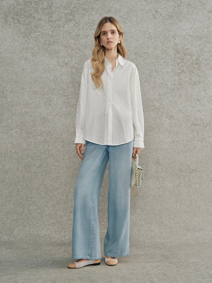 Full-body look: Andrea Tang KIARA striped shirt styled with light-wash wide-leg jeans and woven flats