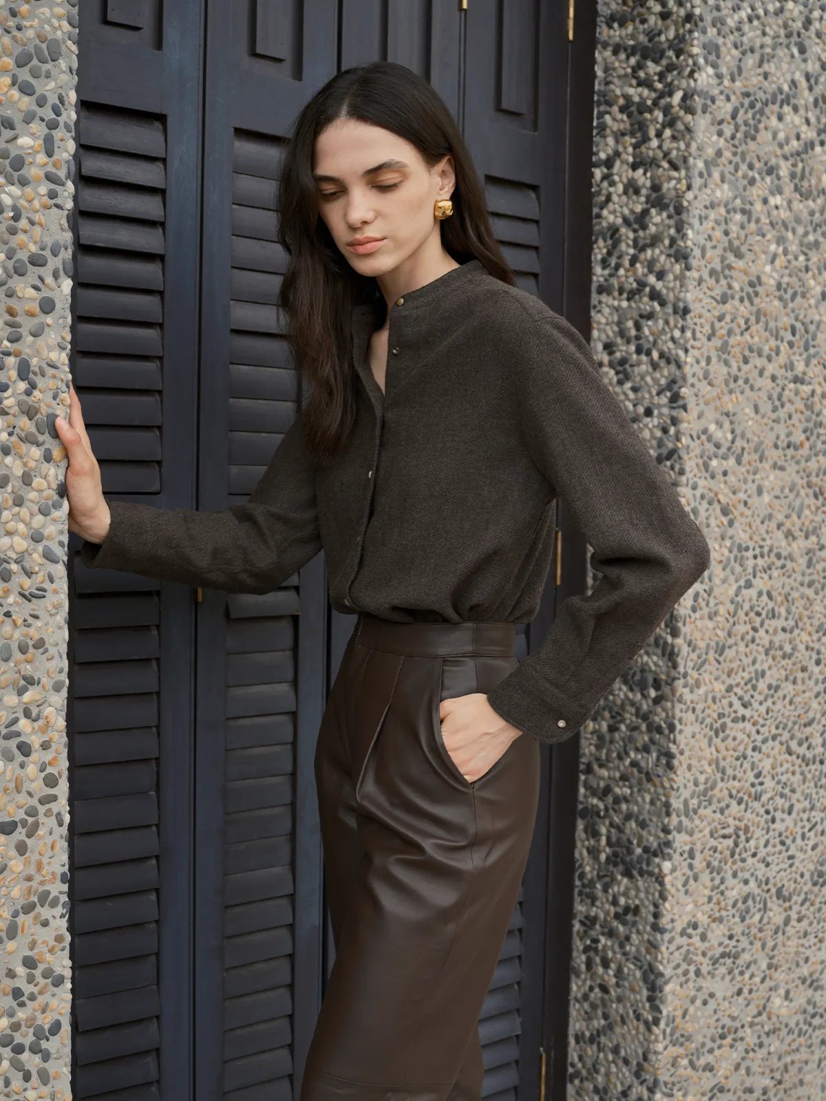 Model wearing WINSLOW shirt with brown leather pencil skirt, outdoor architectural backdrop
