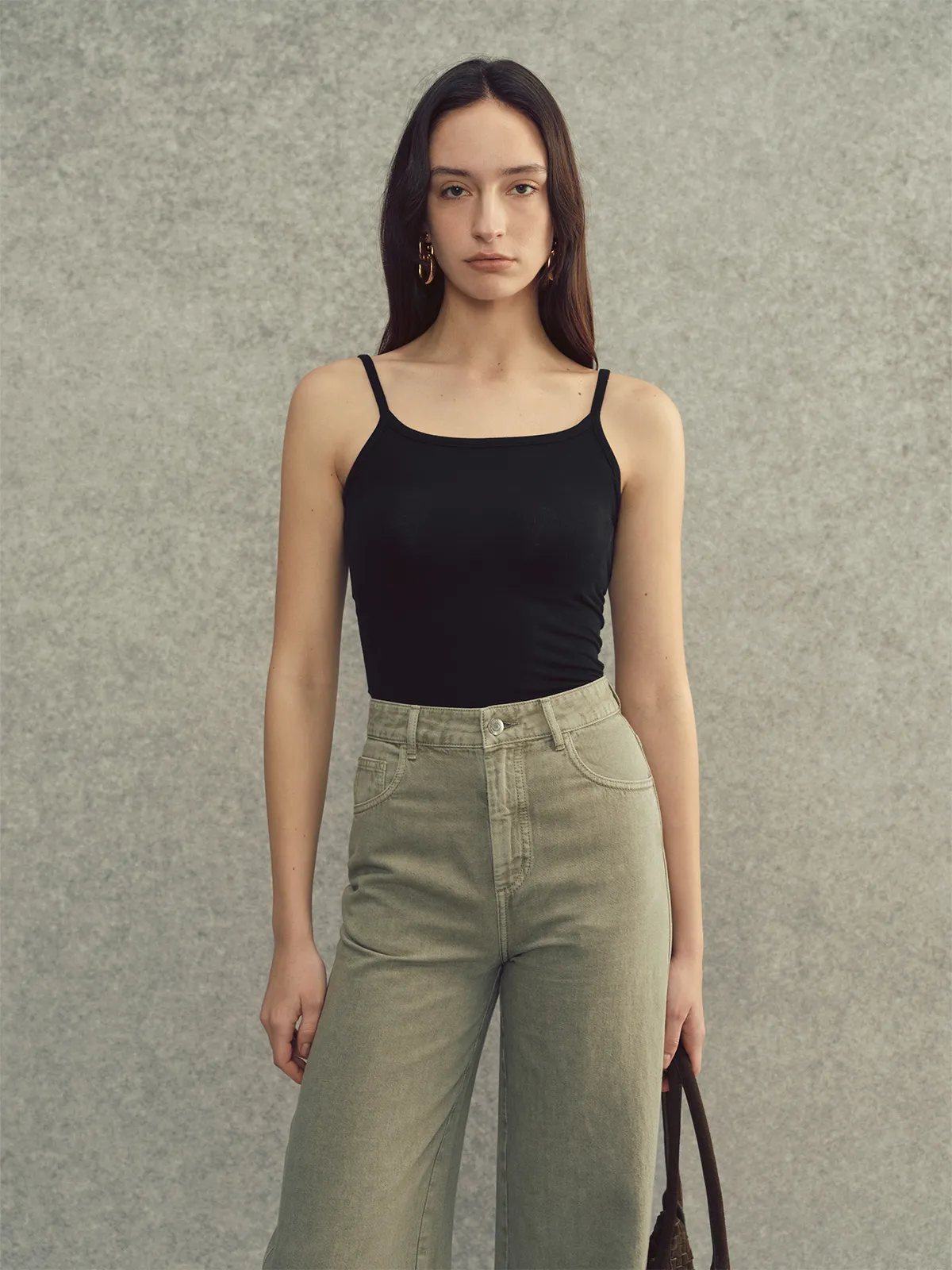 Front view of black LANA camisole with olive green high-waisted jeans — sleek minimalist ensemble