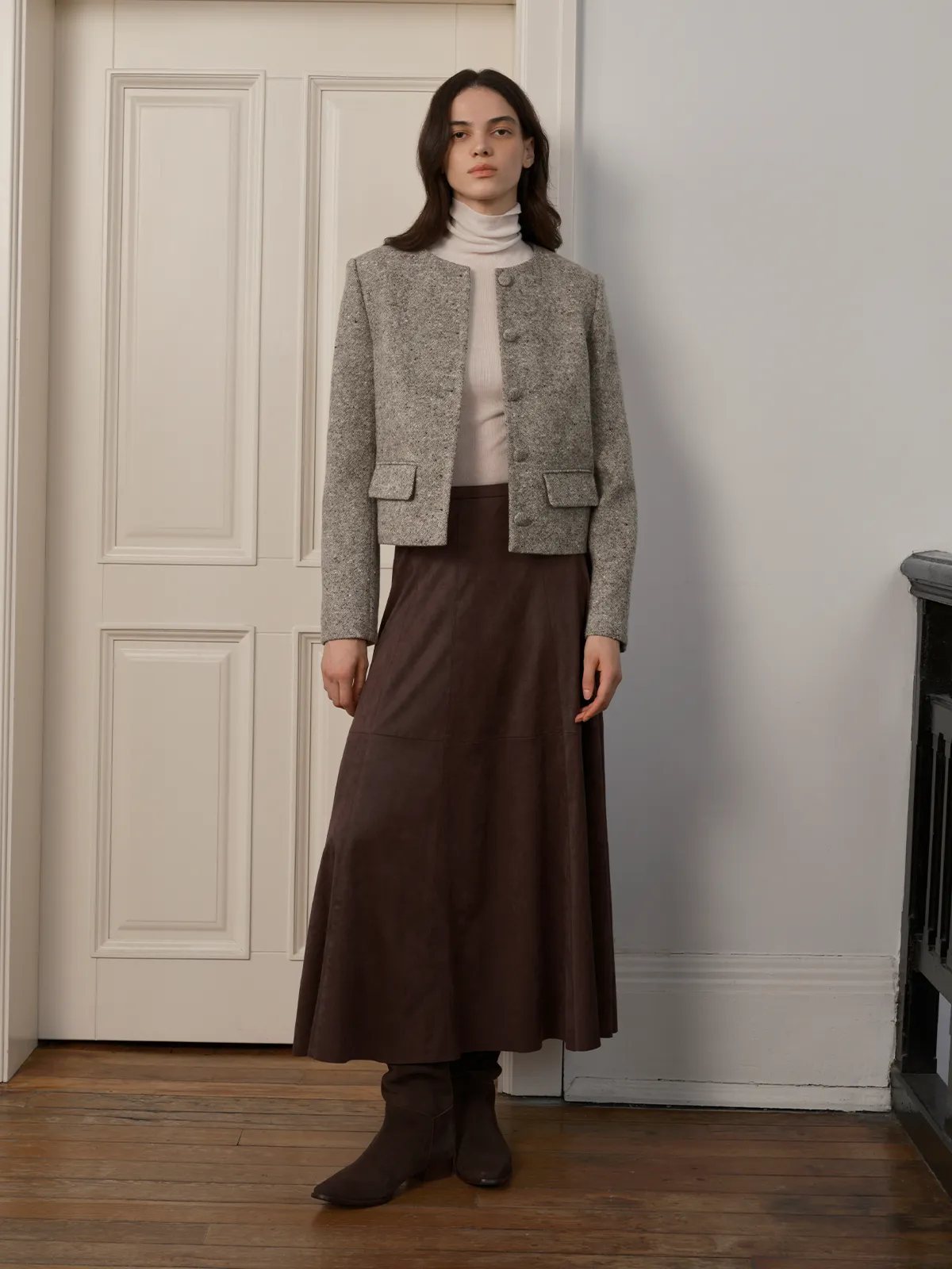 Full-length view of CLARKE Boxy Tweed Jacket with brown leather skirt and ankle boots—classic minimalist elegance