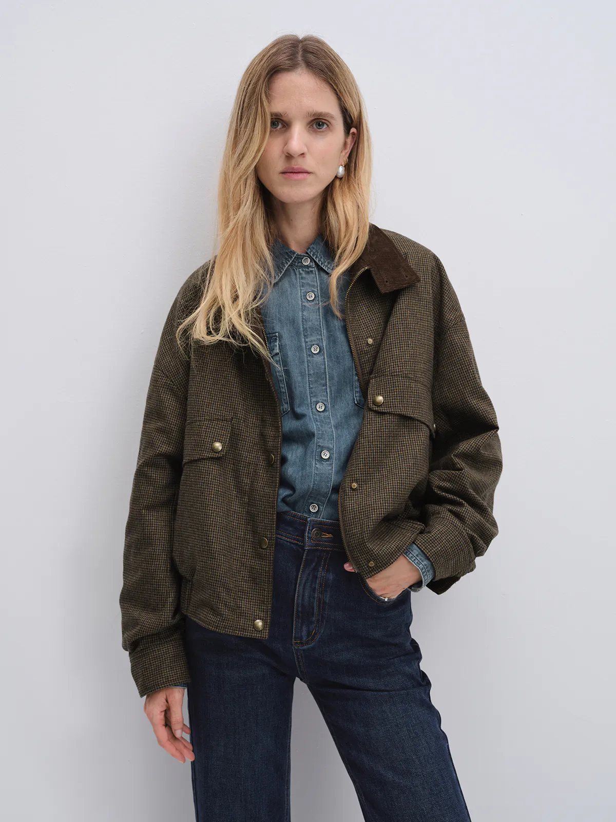 Front view of model in the Brown houndstooth corduroy reversible jacket layered over a denim shirt and jeans.