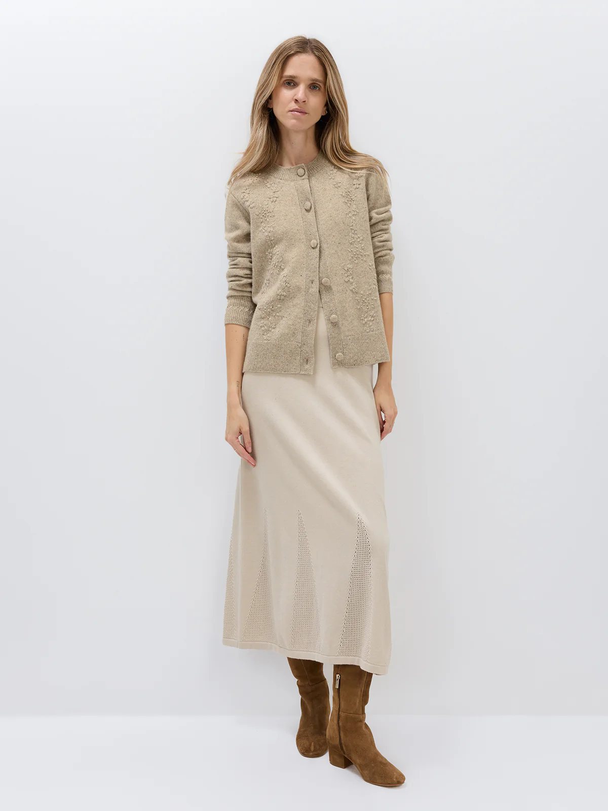 Full-length side view of a model wearing a Light Brown Donegal knit cardigan with floral texture, paired with dark wide-leg pants.