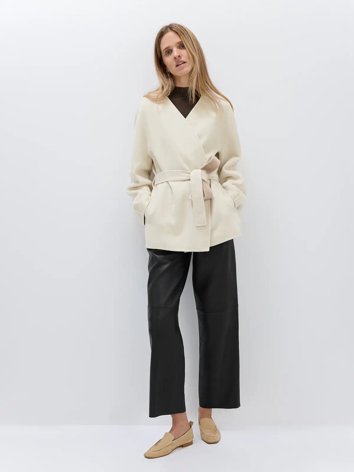 Front view of black sheepskin leather casual pants paired with a color-block vest, blouse, and Mary Janes.
