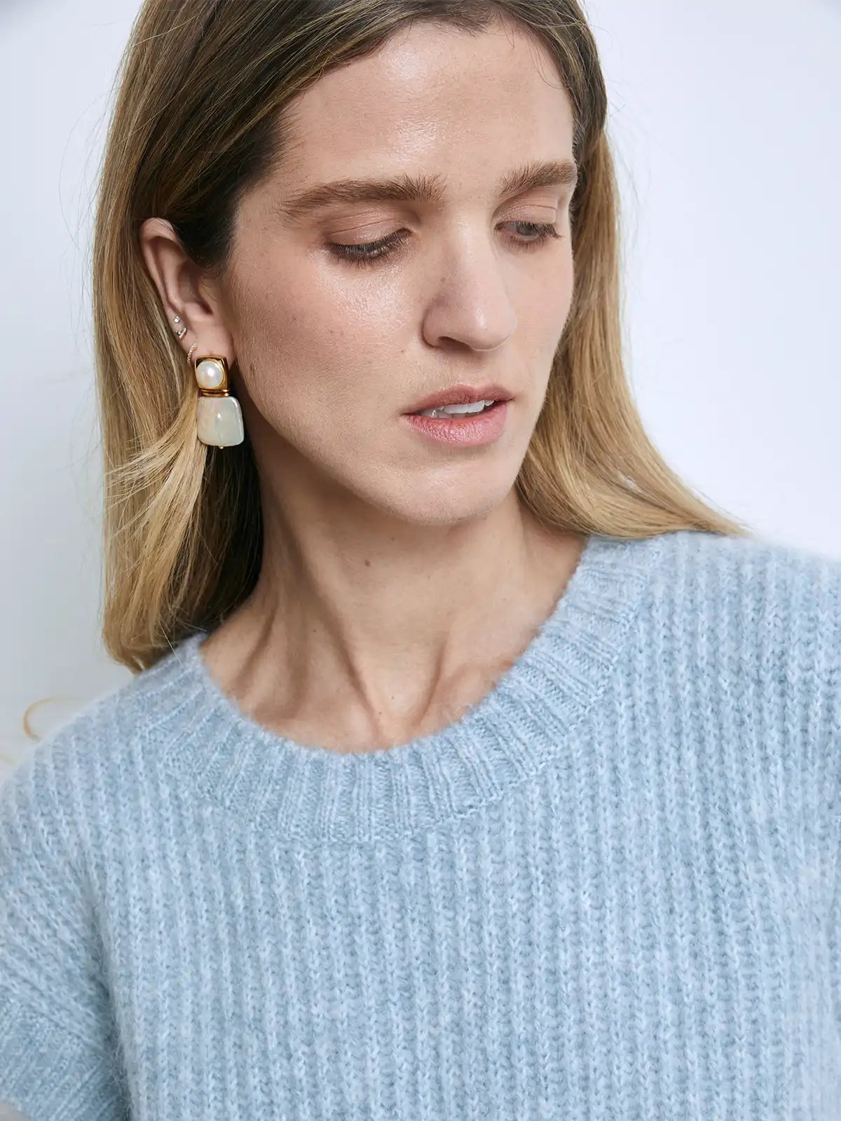 Close-up of a model wearing a light blue ribbed knit vest with soft fuzzy texture and crew neckline.