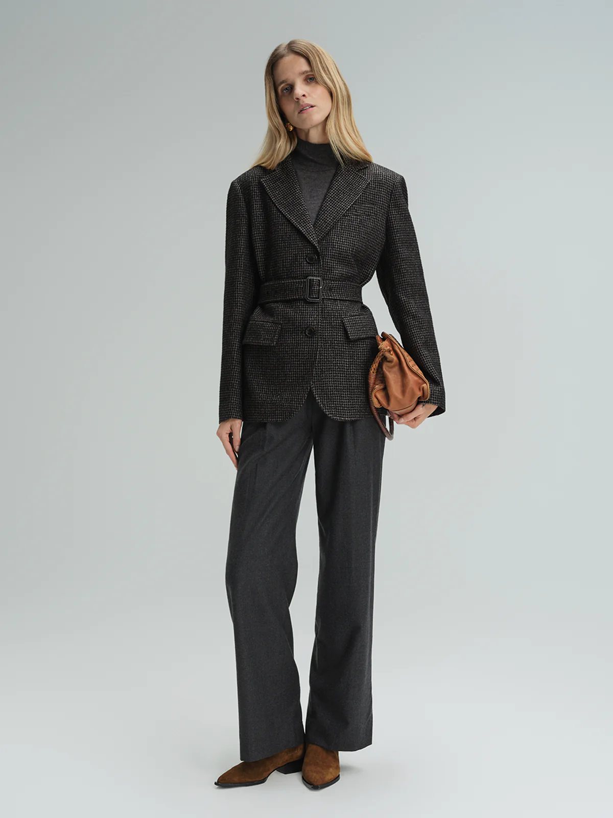 Model in andreatang wool straight-leg trousers and matching houndstooth blazer
