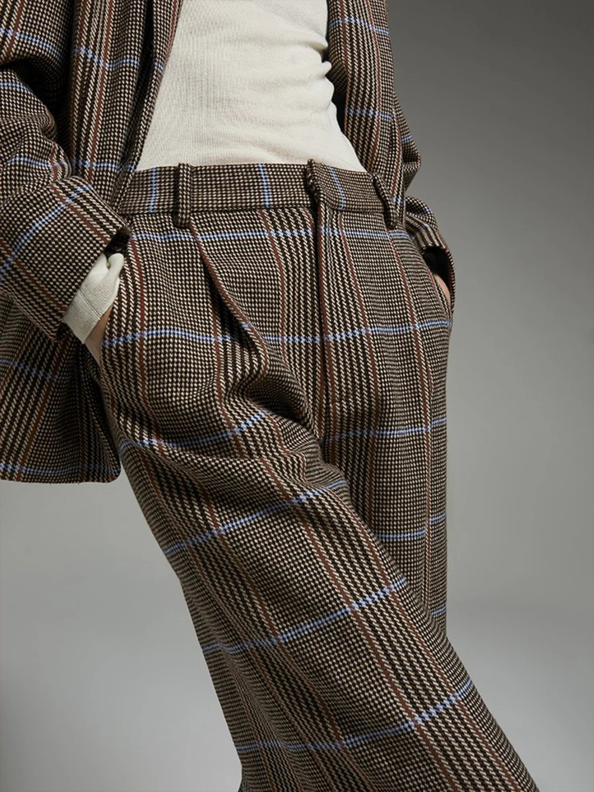 Fabric and waist detail of andreatang British check suit showing belt loops and pleated front
