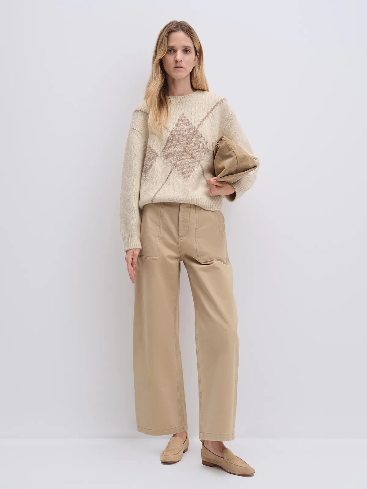 Front view of model wearing khaki cotton utility trousers with wide legs and front pockets.