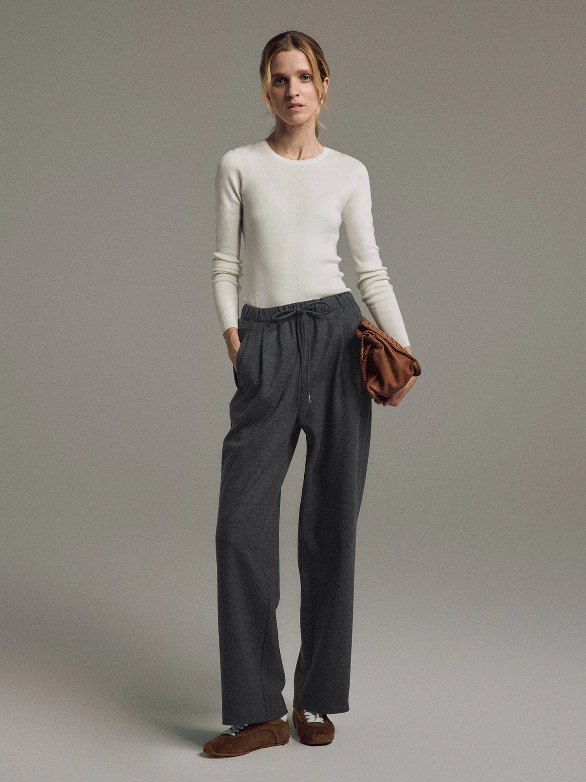 Model wearing Dark Gray wool blend straight trousers with drawstring waist, hands in pockets, front view.