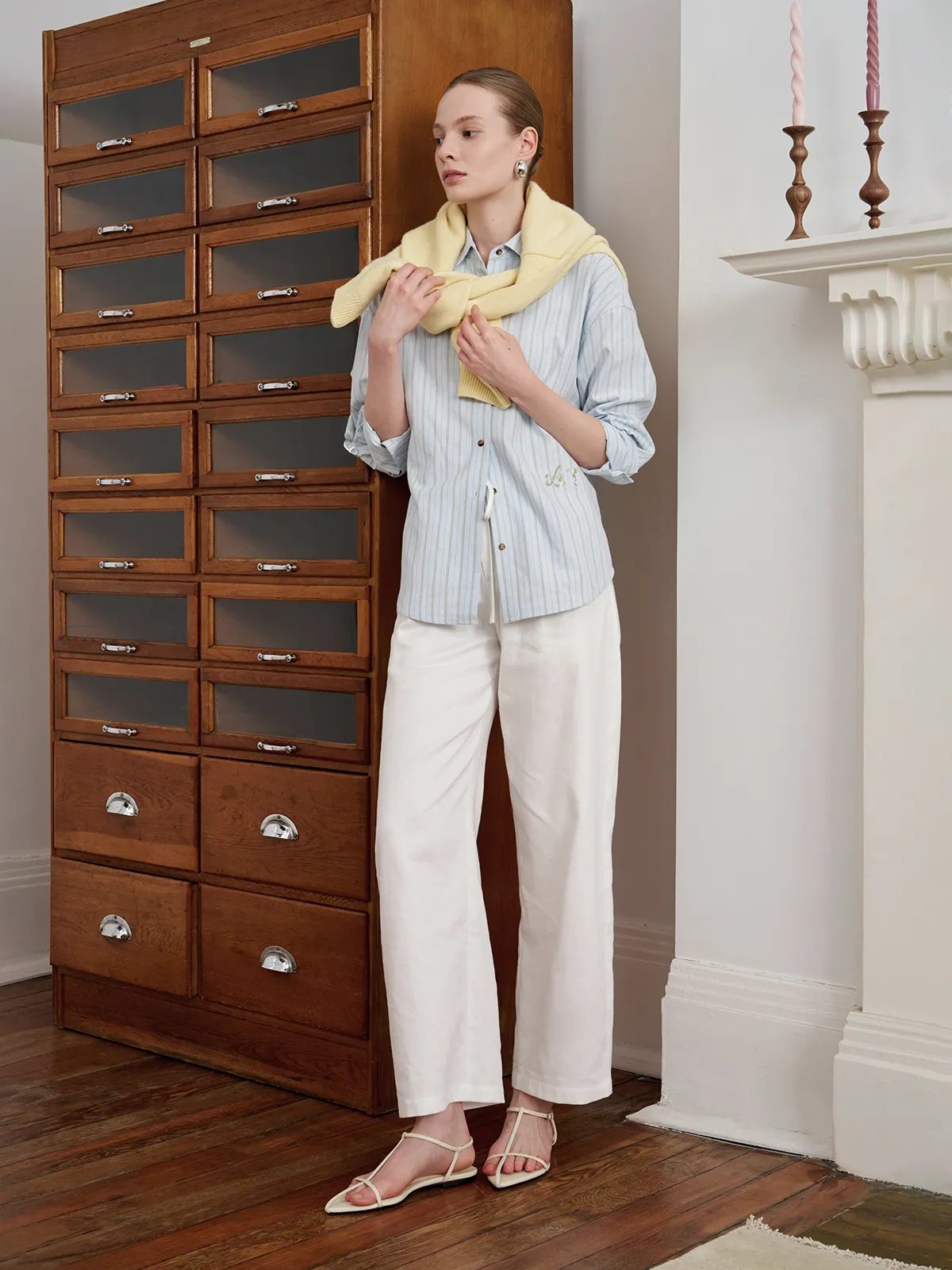 Andreatang TILLY floral embroidered shirt in light blue stripes styled with cream trousers and yellow cashmere scarf, minimalist interior setting