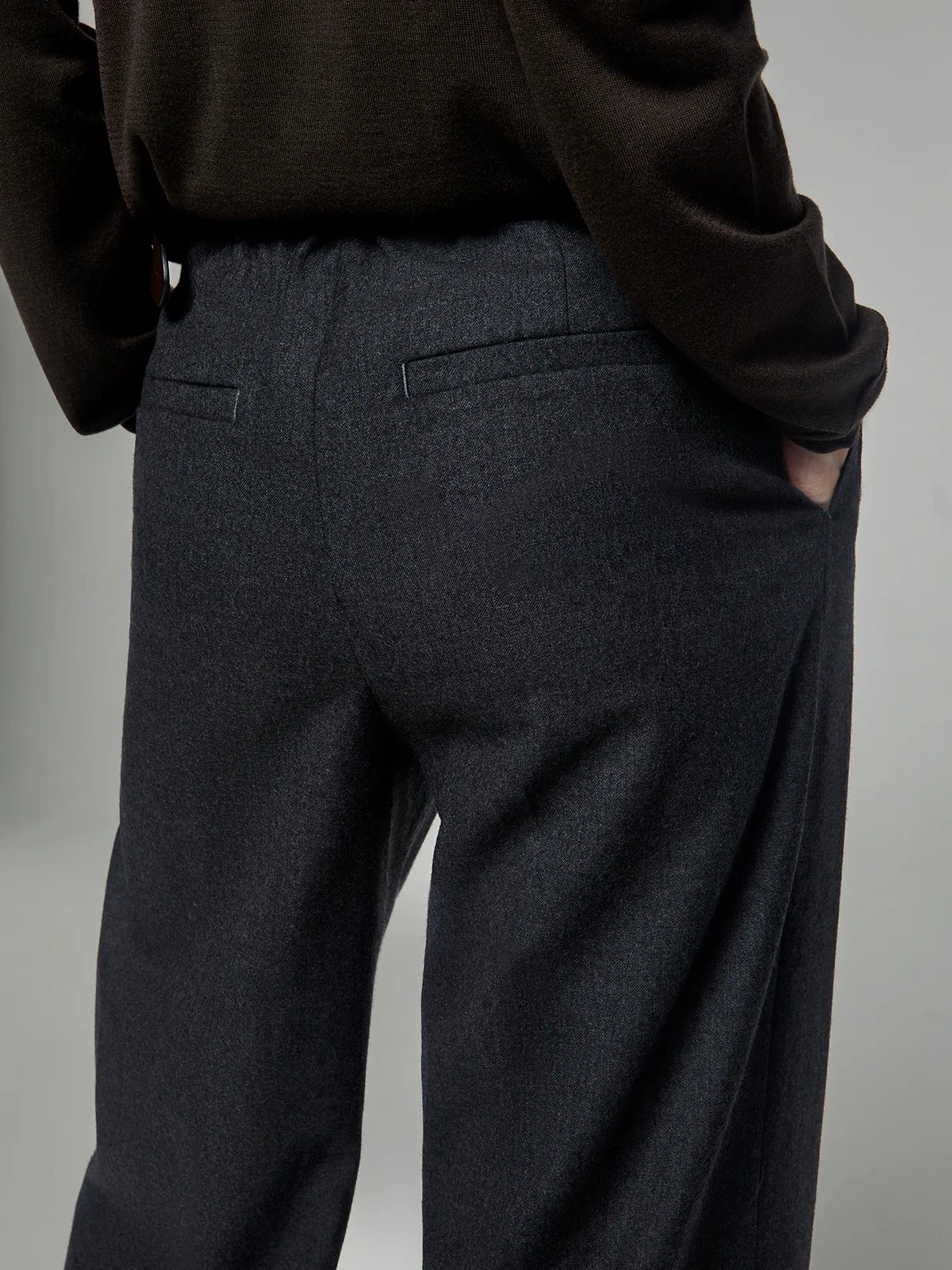 Back view of Gray fine wool wide-leg trousers showing two welt pockets and clean waistband finish.