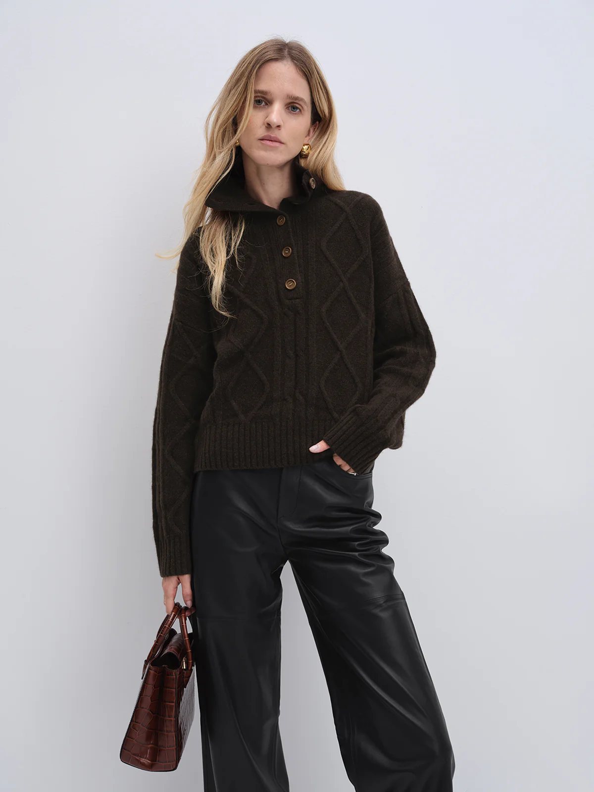 Front view of model in andreatang yak and wool cropped sweater and black trousers