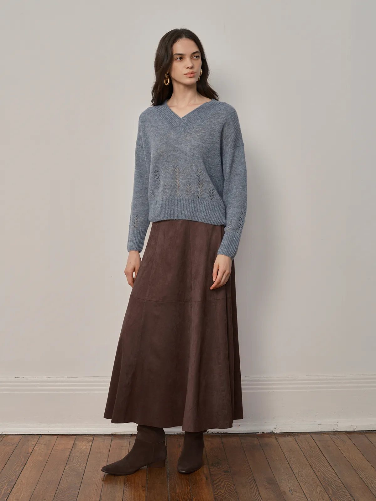 Full-length shot of model in dusty blue AIRY Jumper with brown suede A-line midi skirt and ankle boots