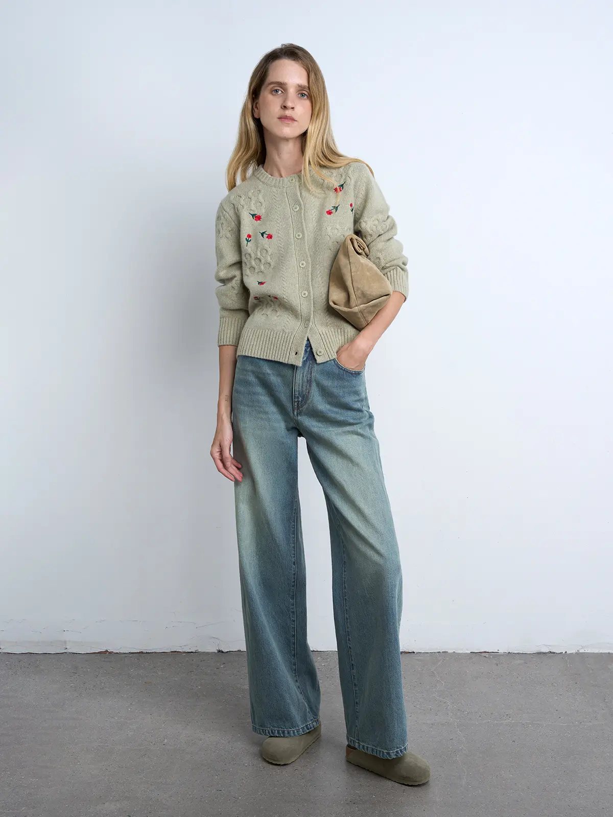 Model wears a Sage Green yak wool cardigan with floral embroidery, ribbed trim, and button closure.